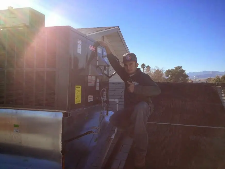 HVAC technician performing Boiler Repair on a rooftop unit in Rye